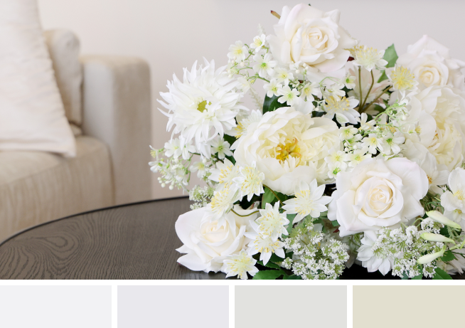 Blumenstrauss in Weiß auf schwarzem Tisch mit weißen Farbkacheln.