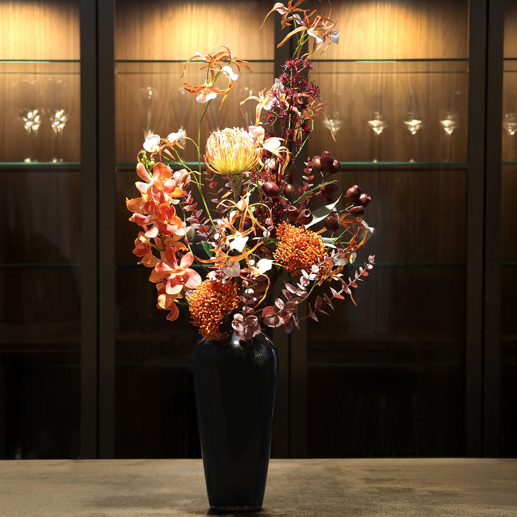 Künstlicher Blumenstrauß African Sunset von Lumisa’s Choice in warmen Farben in schwarzer Vase als stilvolle Dekoration im edlen Interior.