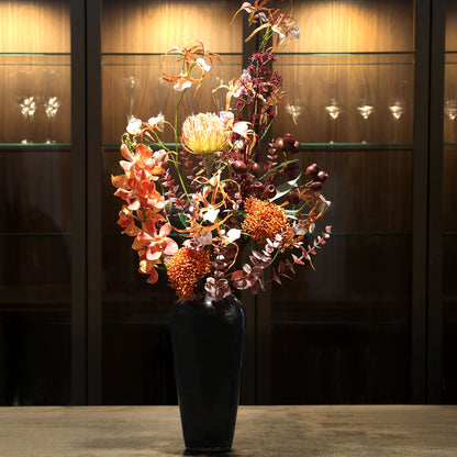 Künstlicher Blumenstrauß African Sunset von Lumisa’s Choice in warmen Farben in schwarzer Vase als stilvolle Dekoration im edlen Interior.