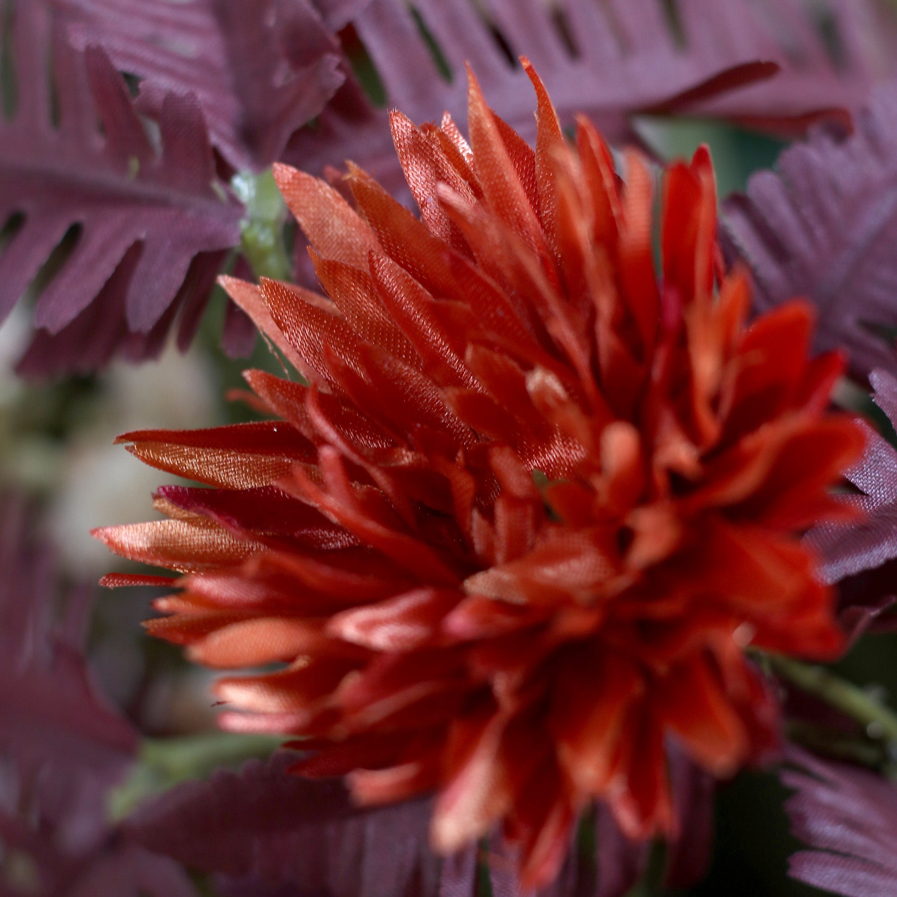 Detailbild einer roten Blüte vom künstlichen Blumenstrauß Cozy Fall von Lumisa’s Choice in warmen Herbstfarben.