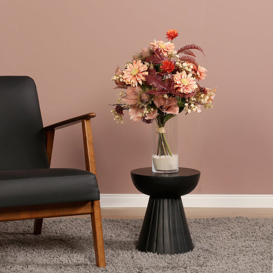 Künstlicher Blumenstrauß Cozy Fall von Lumisa’s Choice in warmen Herbstfarben als dekoratives Arrangement neben schwarzem Sessel.