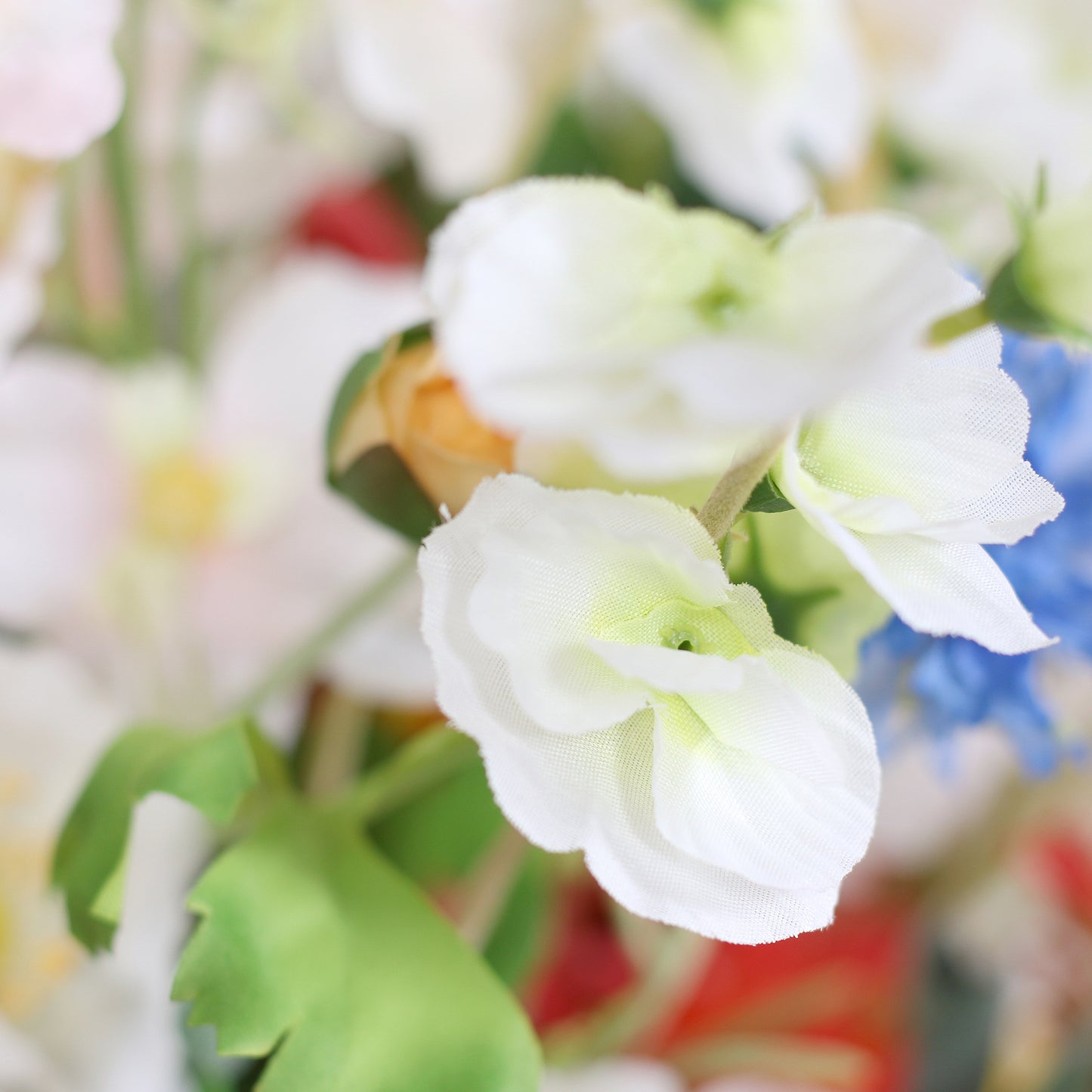 Detailbild einer weißen Blüte vom künstlichen Blumenstrauß Flower Cloud von Lumisa’s Choice in bunten Farben als stilvolle Dekoration.