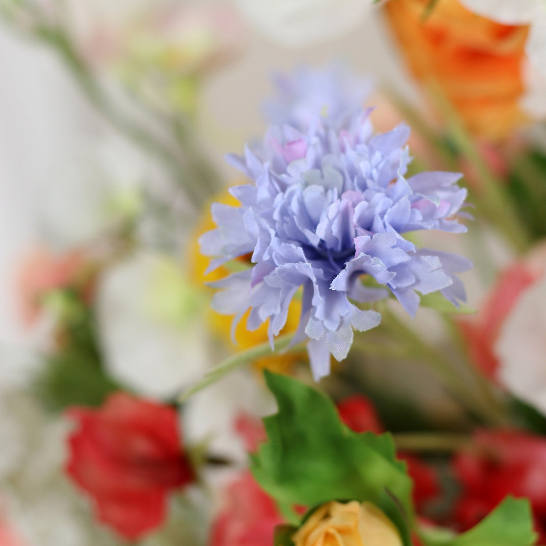 Detailbild einer blauen Blüte vom künstlichen Blumenstrauß Flower Cloud von Lumisa’s Choice in bunten Farben als stilvolle Dekoration.