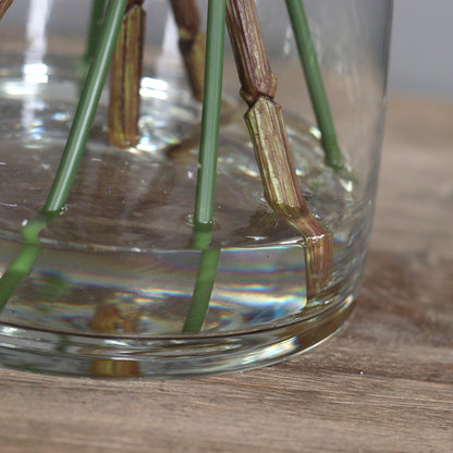 Detailbild einer Glasvase mit künstlichem Wasser und Blumenstiel