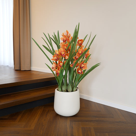 Künstliche Cymbidium Orchidee orange mit Topf im Interior