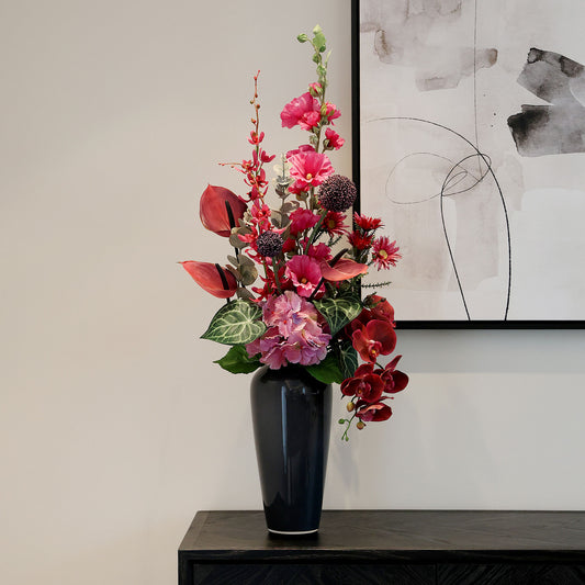 Künstlicher Blumenstrauß Pink Passion von Lumisa’s Choice in kräftigen Pinktönen in schwarzer Vase als moderne Dekoration auf schwarzen Sideboard.