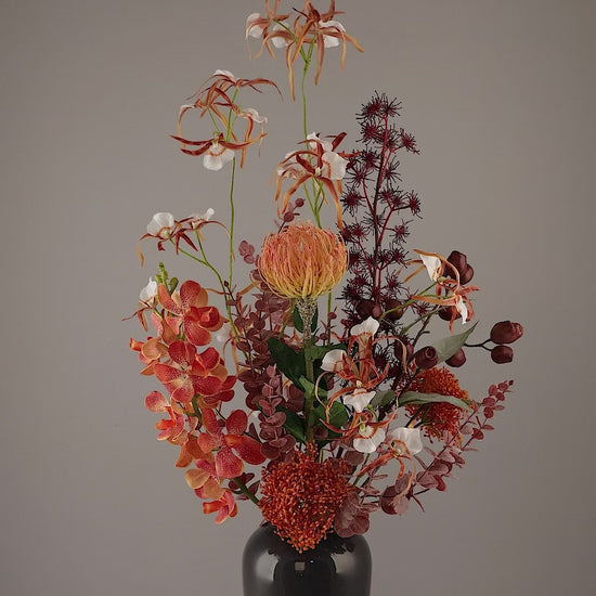 Künstlicher Blumenstrauß African Sunset von Lumisa’s Choice in warmen Farben in schwarzer Vase, 360-Grad-Ansicht mit Drehung.