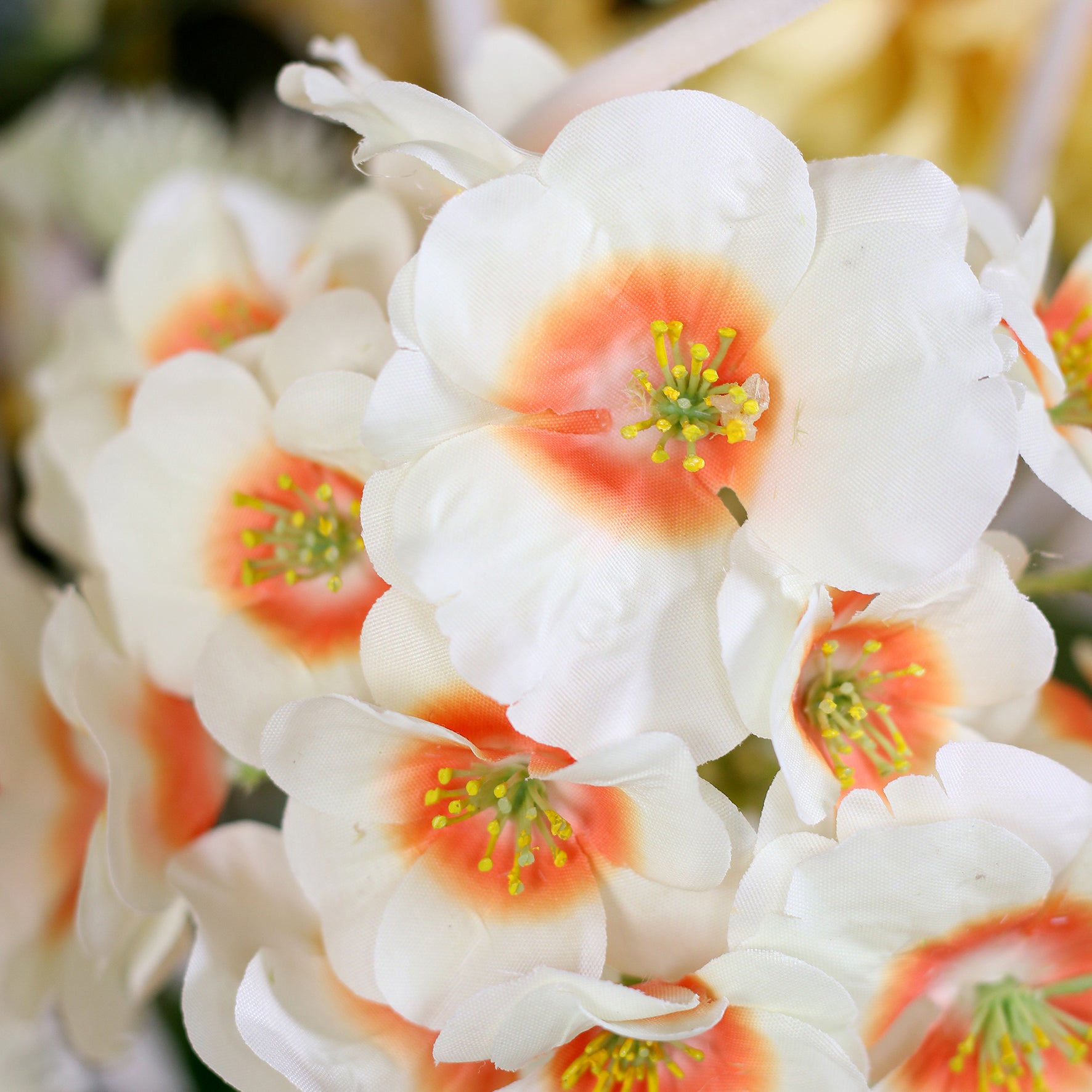 Detailbild einer weiß- orangefarbenen Blüte vom künstlichen Blumenstrauß Ray of Sunshine von Lumisa’s Choice in Gelbtönen.