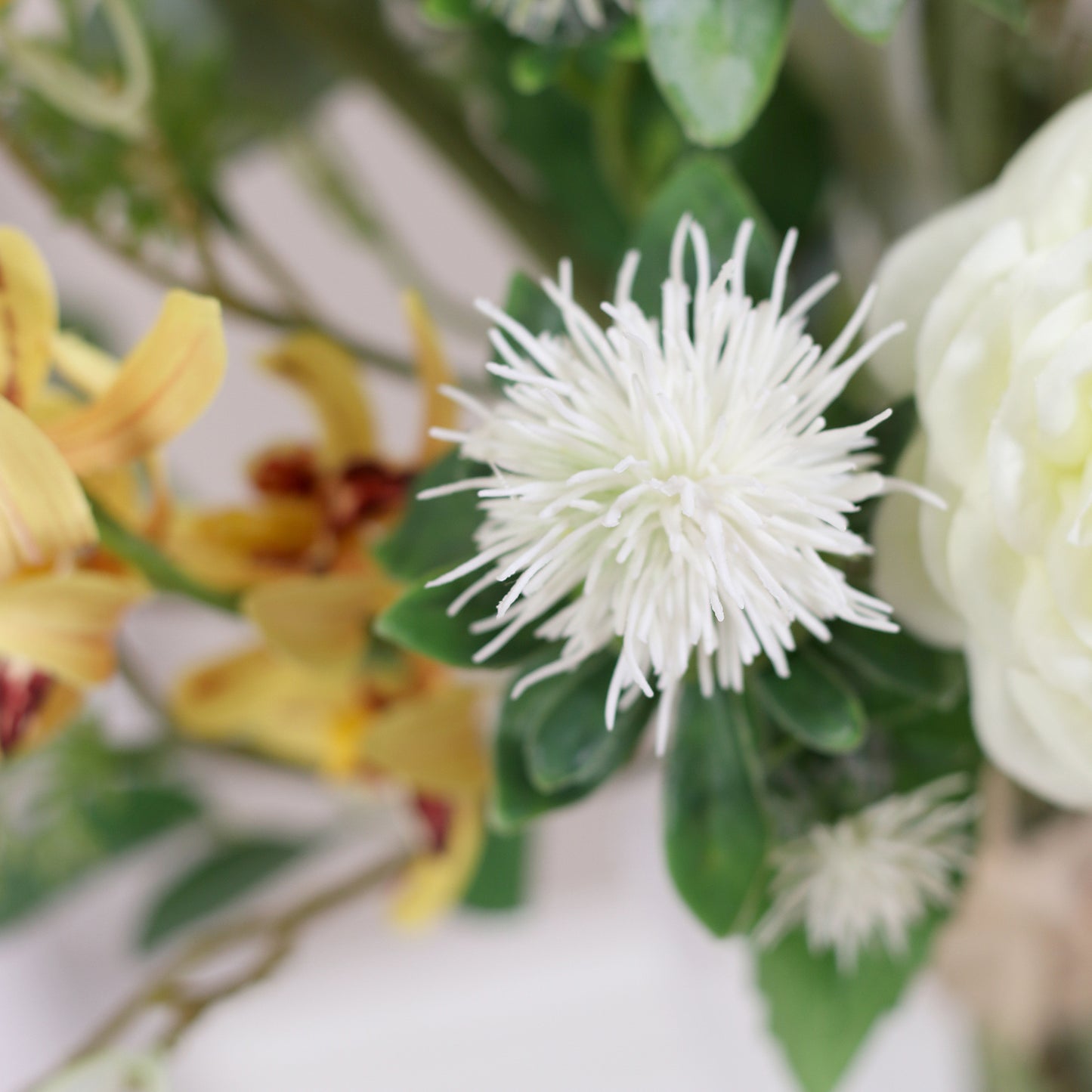 Detailbild einer weißen Blüte vom künstlichen Blumenstrauß Ray of Sunshine von Lumisa’s Choice in Gelbtönen.