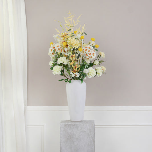 Künstlicher Blumenstrauß Ray of Sunshine von Lumisa’s Choice in Gelbtönen in weißer Vase als elegante Dekoration vor heller Wand.