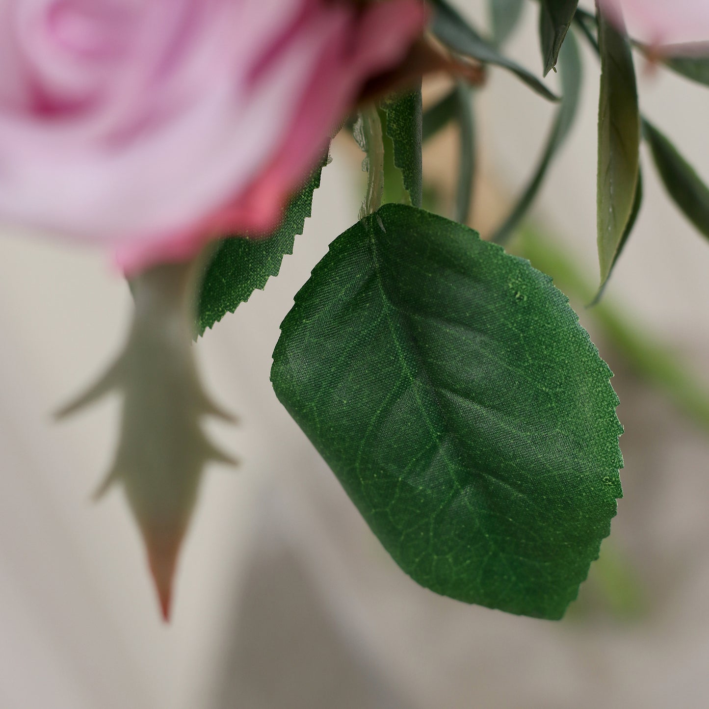 Detailbild eines grünen Blatts vom künstlichen Blumenstrauß Rose Mono Bouquet Rosée von Lumisa’s Choice in zarten Rosétönen als elegante Dekoration.