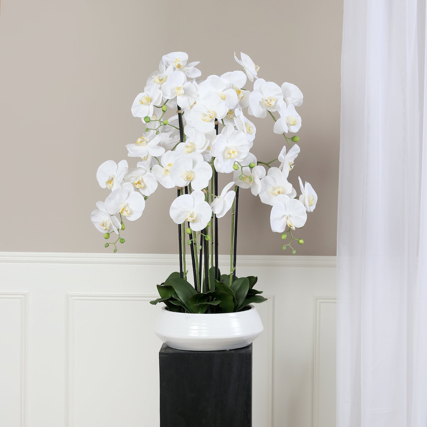 Künstliche Signature Orchidee groß mit stylischem Topf auf Podest im Interior