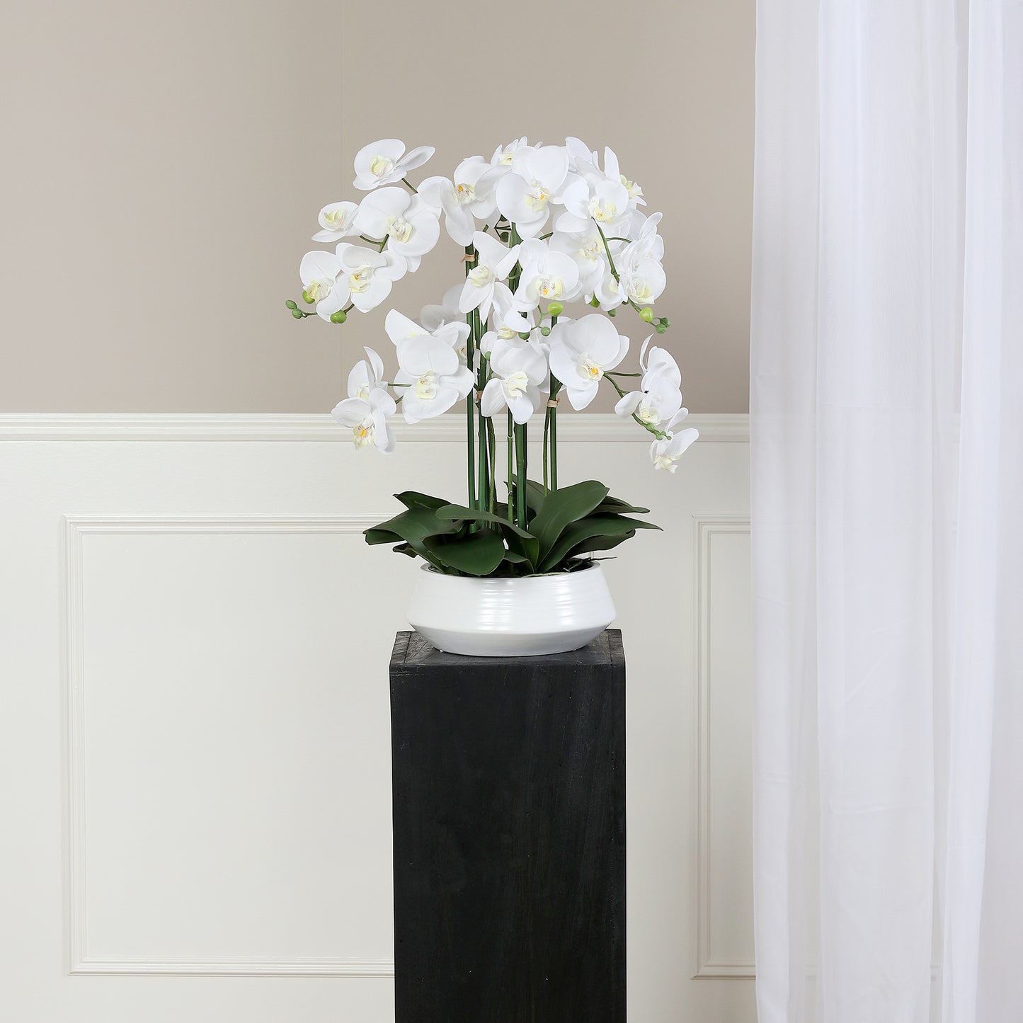 Künstliche Signature Orchidee klein mit stylischem Topf auf Podest im Interior