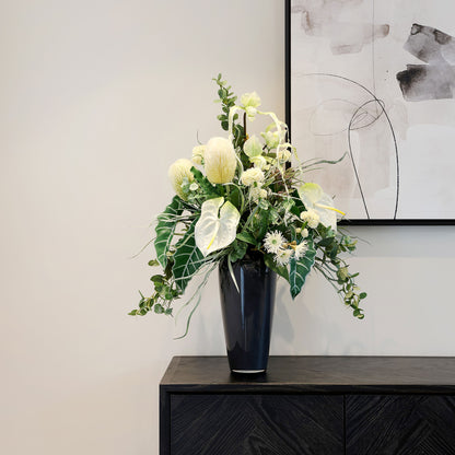 Künstlicher Blumenstrauß Soul of Nature von Lumisa’s Choice in Grün- und Weißtönen in eleganter schwarzer Vase auf Sideboard.