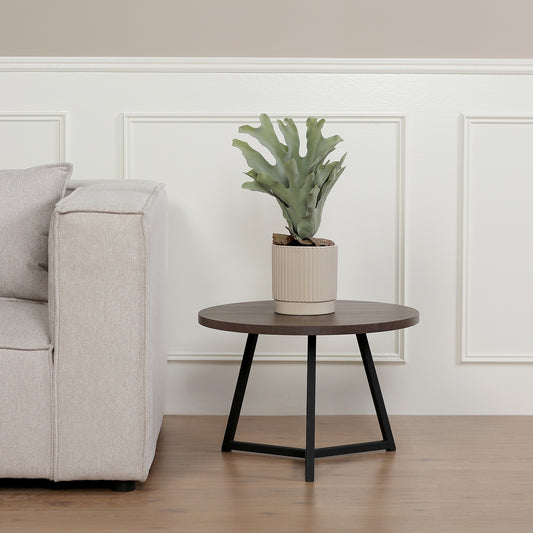 Künstlicher Staghorn-Farn Groß von Lumisa’s Choice in beigem Keramiktopf auf rundem Beistelltisch neben hellem Sofa.