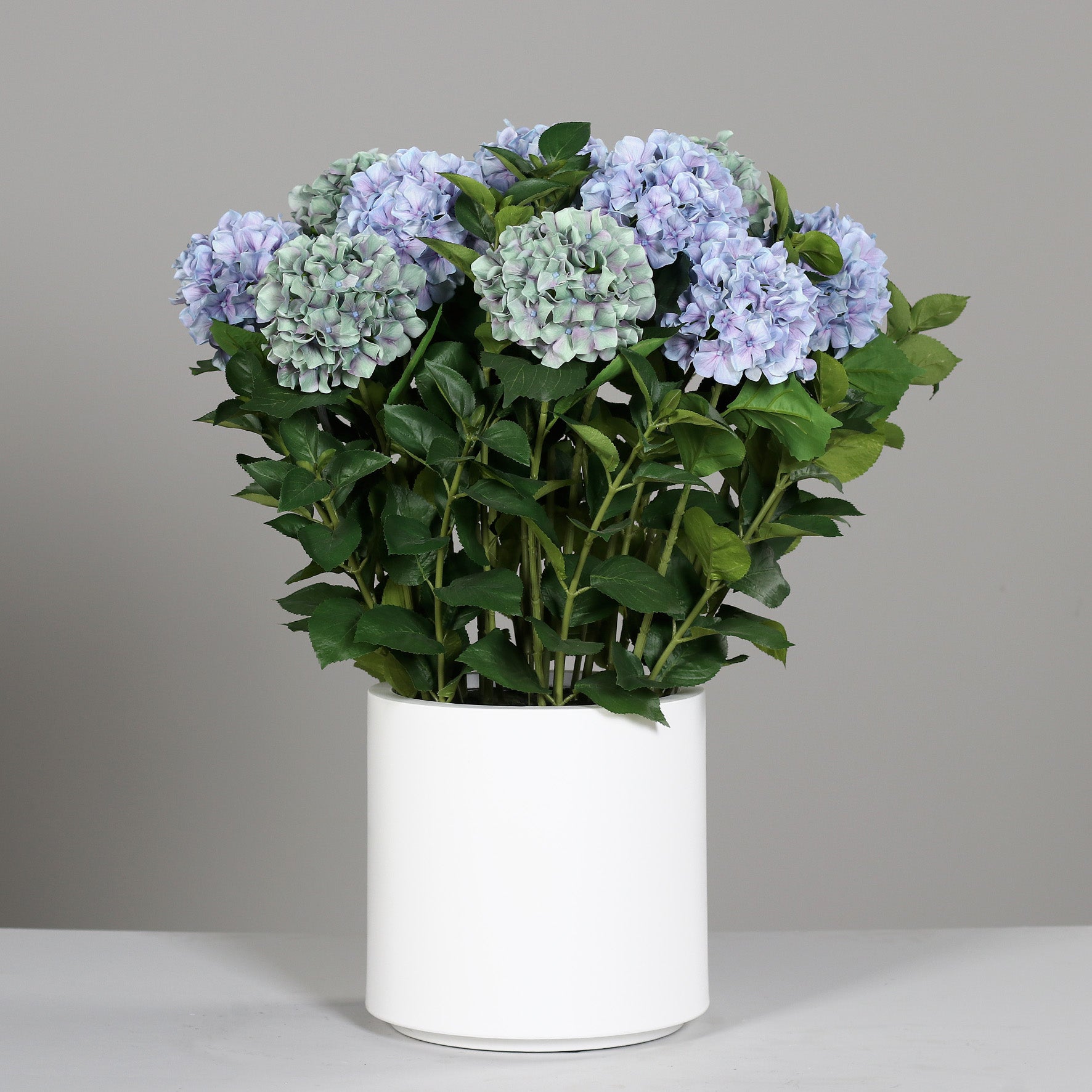 Großes künstliches Premium Hortensien-Arrangement im Topf blau auf Tisch