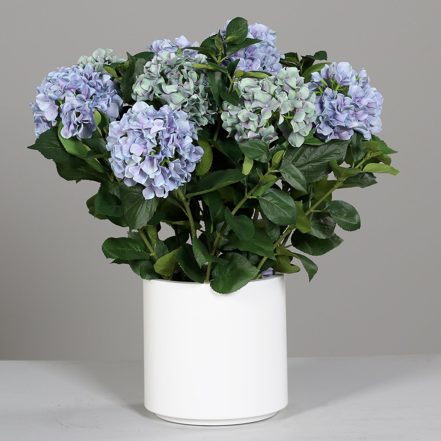 Kleines künstliches Premium Hortensien-Arrangement im Topf blau auf Tisch