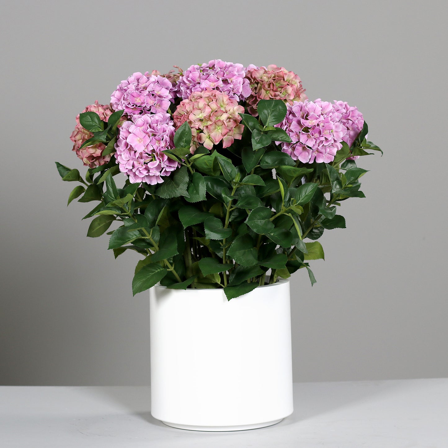 Kleines künstliches Premium Hortensien-Arrangement im Topf pink auf Tisch