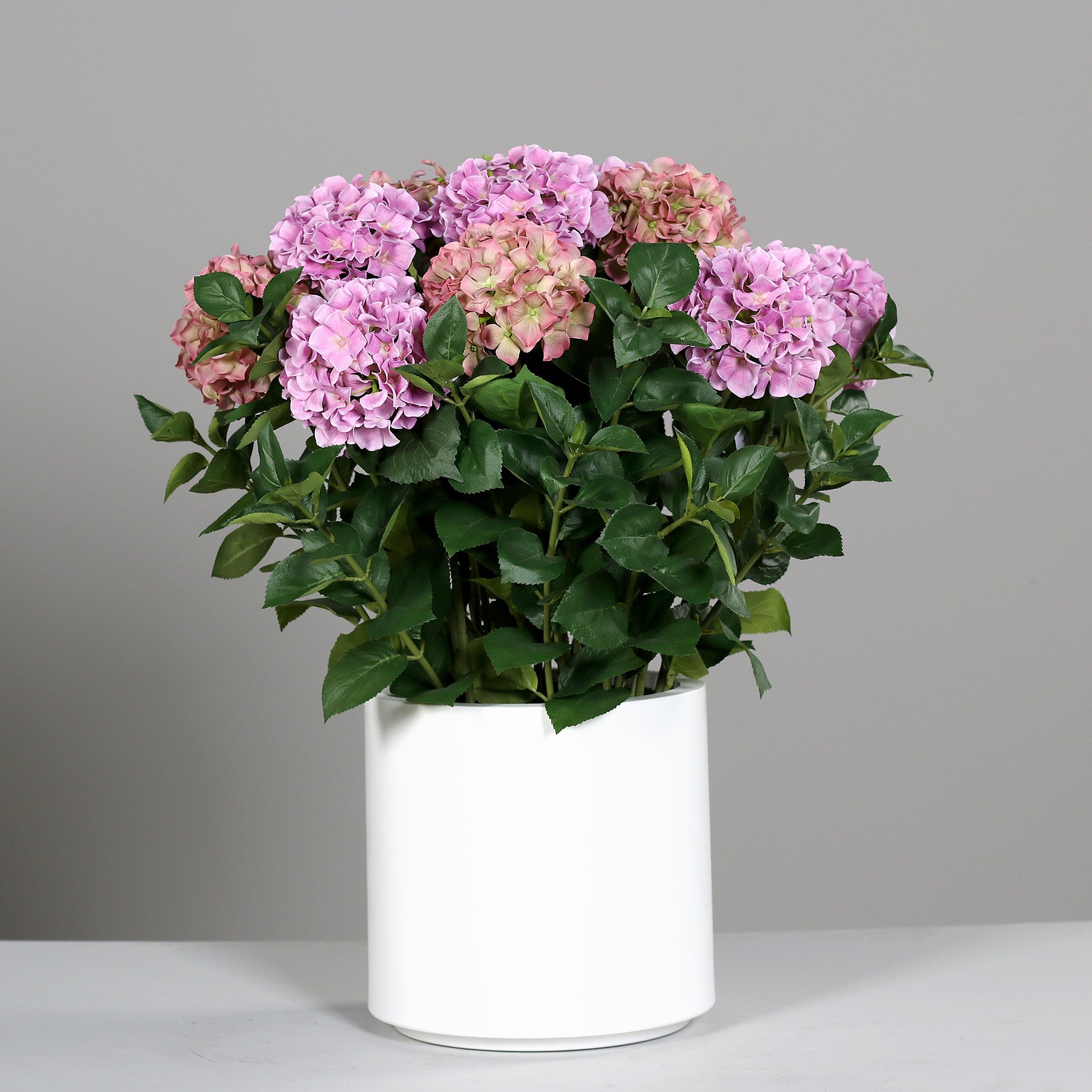 Kleines künstliches Premium Hortensien-Arrangement im Topf pink auf Tisch