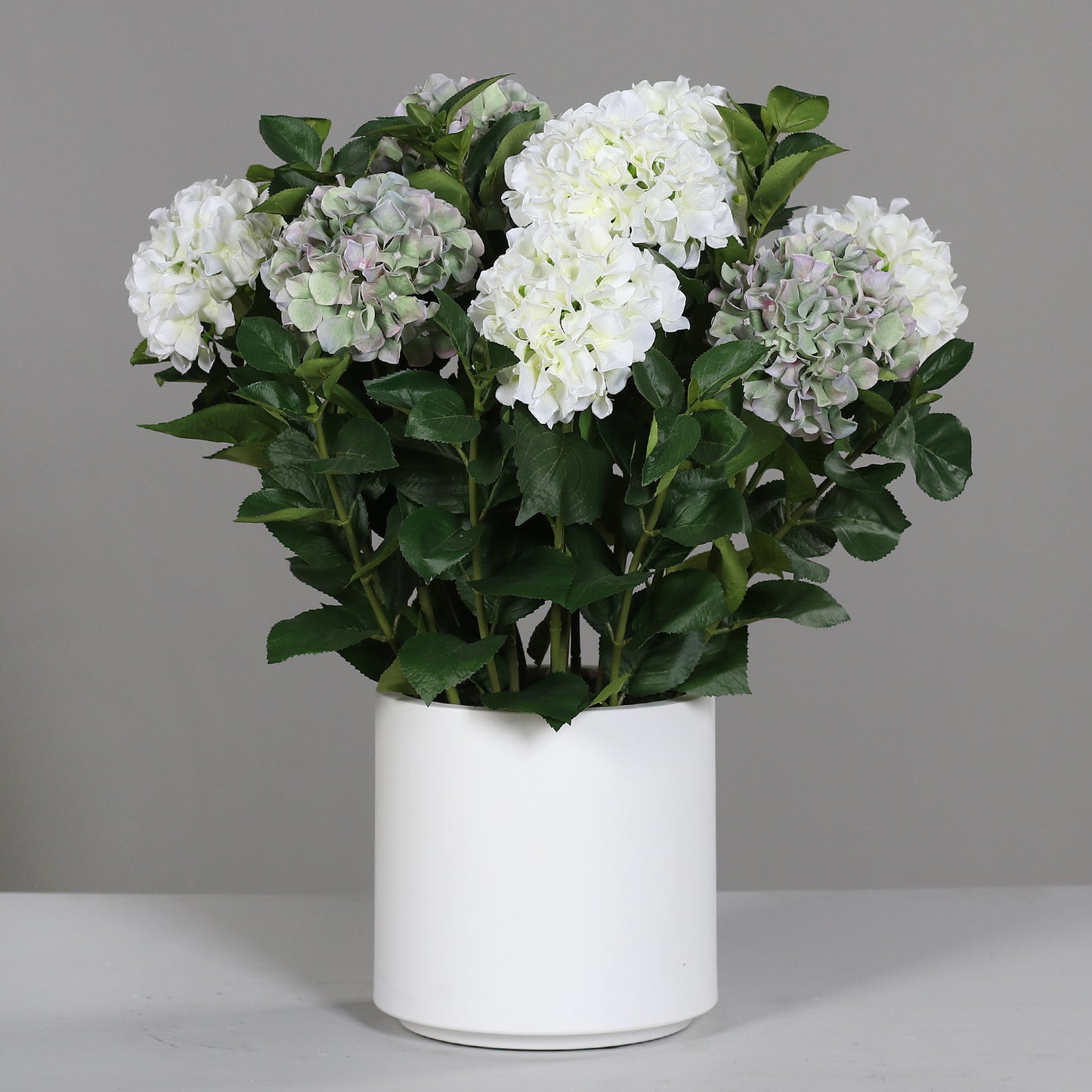 Kleines künstliches Premium Hortensien-Arrangement im Topf weiß-grün auf Tisch